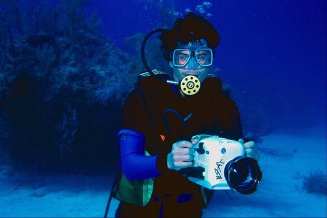 аквалангист занимается подводной съемкой