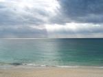 Photo of the sea and the sky with a solar gleam in clouds