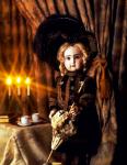 Кукла в черной шляпке у чайного стола со свечами